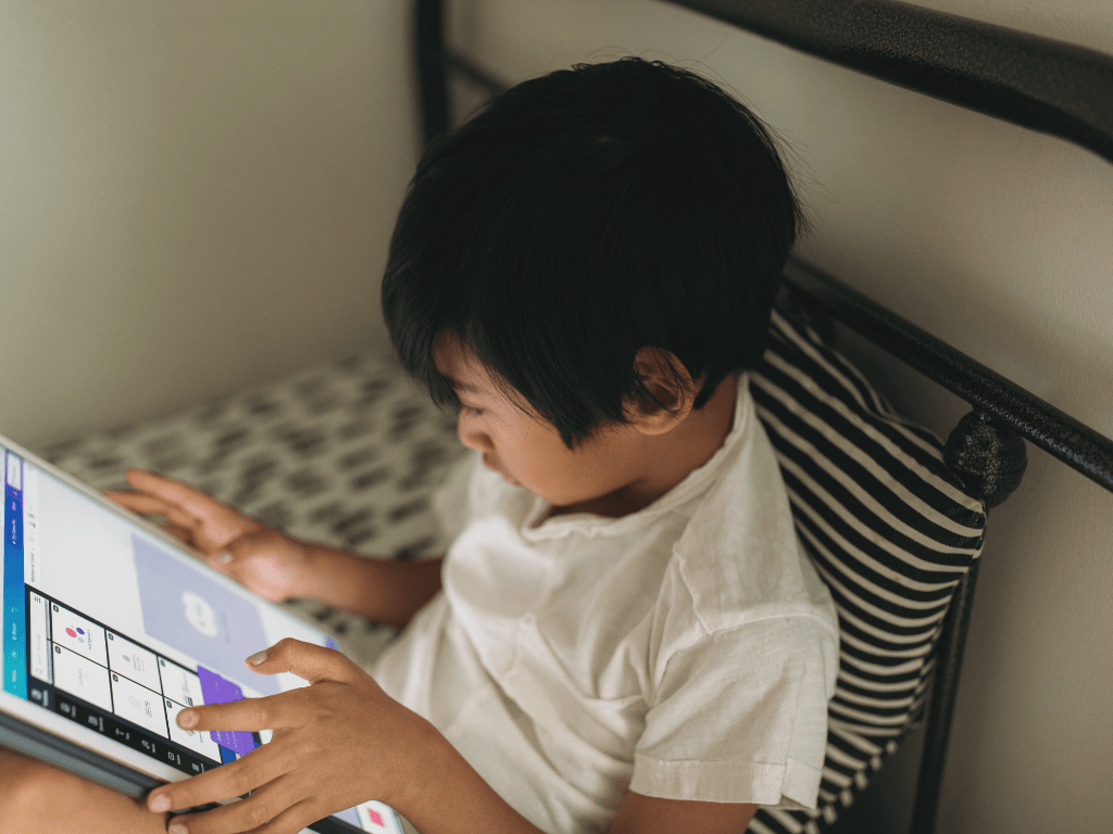 child on ipad in bed