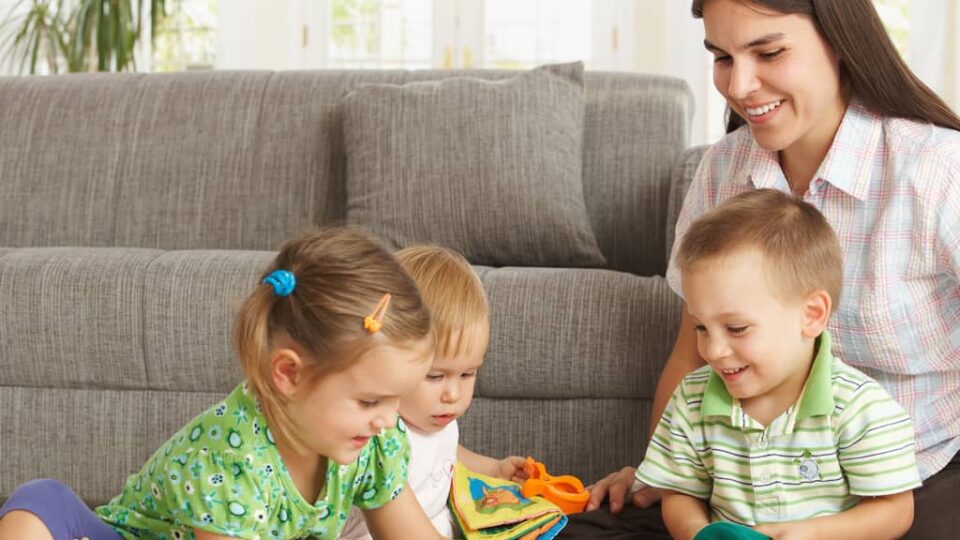 mother playing with three children at home